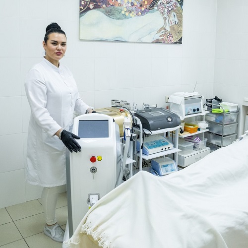 Косметолог салона красоты На Речной в Красногорске демонстрирует аппарат для лазерной эпиляции, готовый к процедуре.